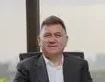 Confident middle-aged businessman in an elegant office with city view.